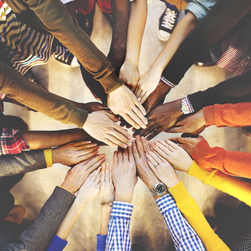 A group of people's hands in the middle for teamwork